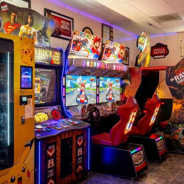 A vibrant arcade room with a Pikachu vending machine, Mario Kart, and other video games.